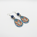 Bull skull teardrop earrings on white surface