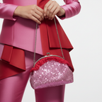 Woman holding pink sequin bag by chain strap